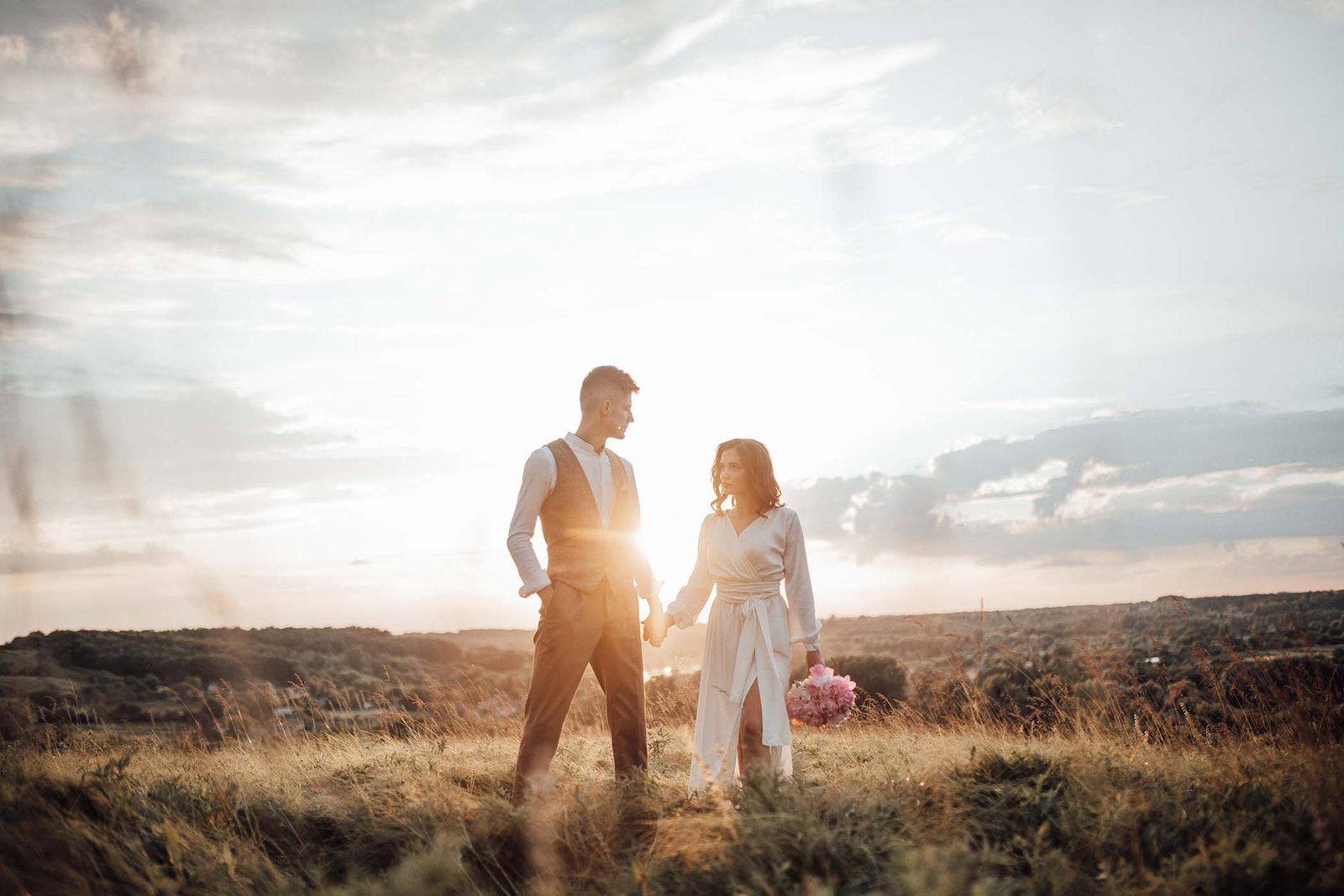 Couple walking at sunset in a field