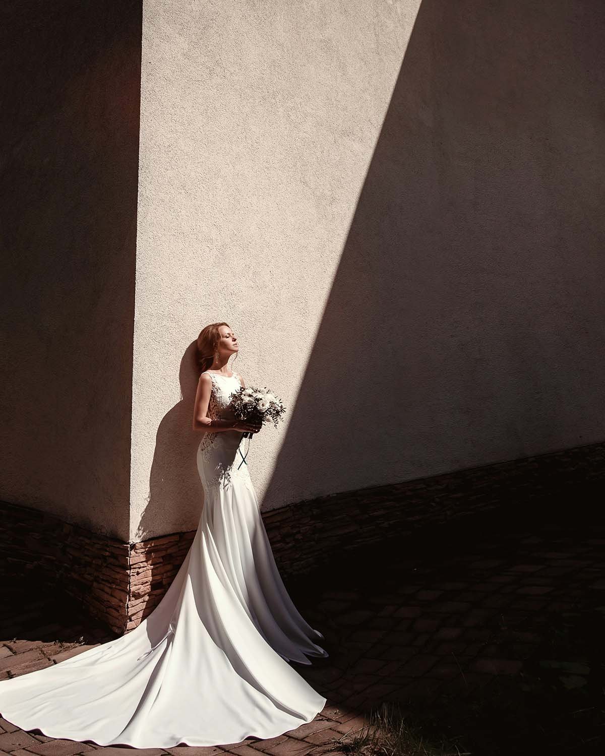 Bride in dramatic light and shadow architecture