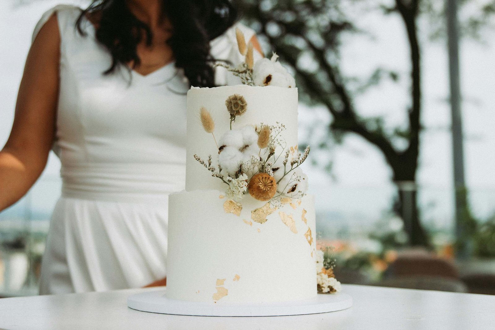Bride beside a pressed-flower wedding cake